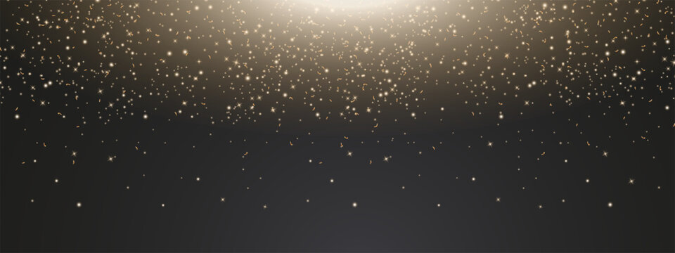Golden glitter, glowing stars and confetti falling from above on a dark background with copy space, ideal for elegant festive and luxury designs