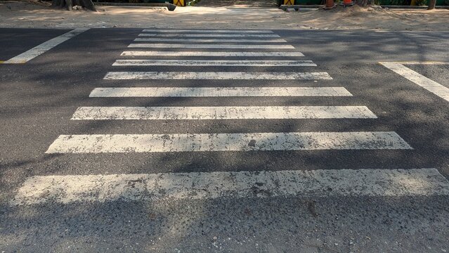 White zebra crosswalk lines on asphalt road street top view