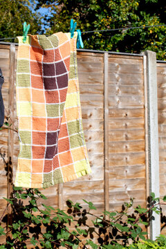 Clothes pegs and laundry garments hanging on a single long washing line being held up by pegs, tradition drying method