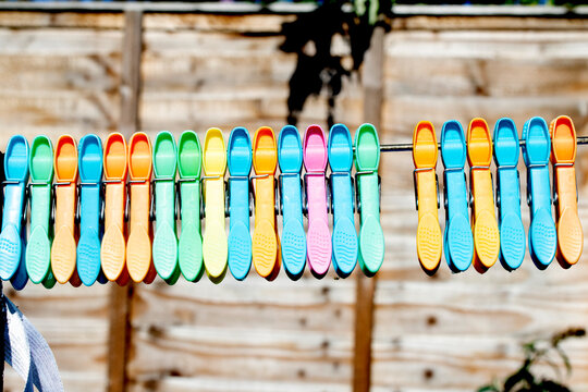 Clothes pegs and laundry garments hanging on a single long washing line being held up by pegs, tradition drying method