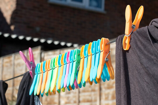 Clothes pegs and laundry garments hanging on a single long washing line being held up by pegs, tradition drying method