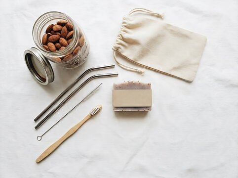 Zero waste lifestyle flat lay with glass jar of almonds bamboo toothbrush and reusable metal straws