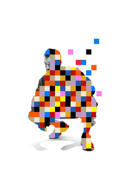 Thoughtful young man crouches as colorful pixels dissolve around him in white studio with quiet focus. Personal change, digital identity, future transformation concept.