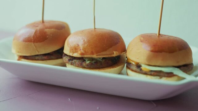 mini burgers or sliders served on a stylish wooden board