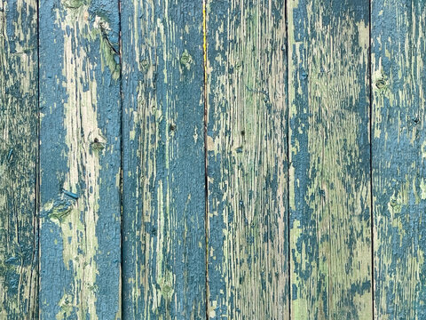 Weathered blue wooden planks with heavily peeling paint and a rustic distressed texture.