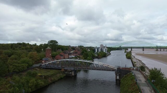 Plane flying over ship canal and Runcorn old quay swing bridge Mersey waterfront