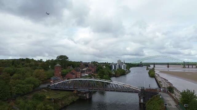 Plane flying over Runcorn old quay swing bridge on the ship canal Mersey waterfront