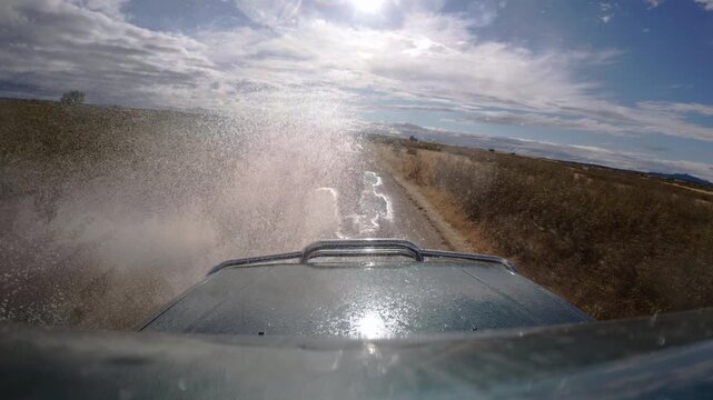 Slow Motion Off Road Vehicle Splashing Through Muddy Puddles