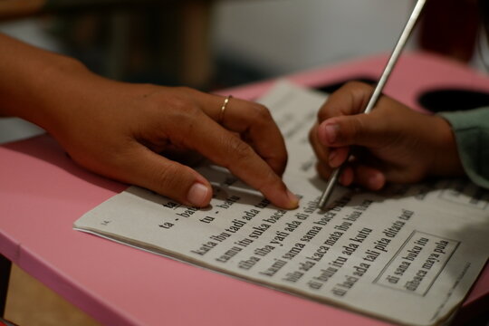Mother and Child Doing Homework Together with Pen and Paper