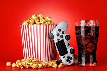 Popcorn, cola and gamepad on red background © Evgeny Karandaev