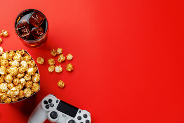 Popcorn, cola and gamepad on red background © Evgeny Karandaev