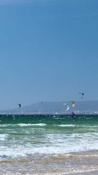Kiteboarding kite surfing kiteboarder kite surfer kites on the Atlantic ocean beach at Fonte da Telha beach, Costa da Caparica, Portugal