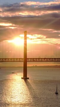 Sunset timelapse of Lisbon's 25th of April Bridge over the Tagus River, linking Almada on the Setubal Peninsula, Portugal. Zoom in