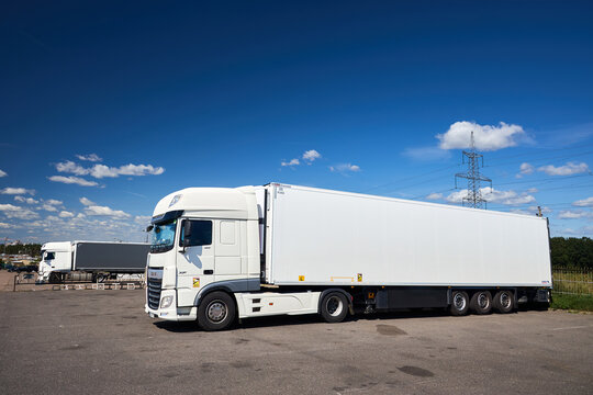 Berlin, Germany - August, 13 2026: White DAF XF semi truck with refrigerator trailer parked on asphalt lot under blue sky, cargo transportation and logistics shipping delivery vehicle