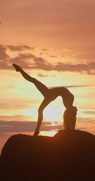 Woman Performing Yoga Pose Silhouette on Rock at Sunset