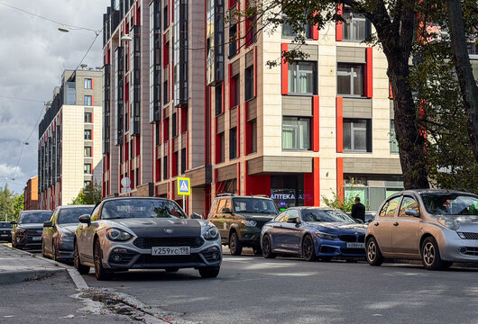 Silver Abarth 124 Spider luxury compact roadster model car parked outdoors. Premium Italian rear-wheel drive RWD sports automobile with matte black hood bonnet and stylish convertible design profile. 