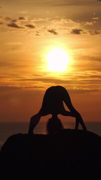 Woman Practicing Yoga Silhouette Against Golden Sunset Sky