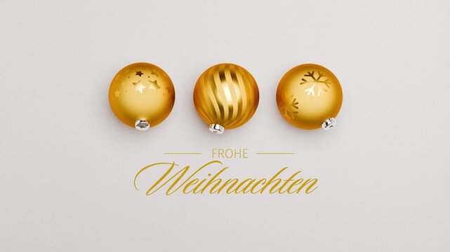Three golden christmas baubles spinning on a paper surface. German language Merry Christmas messages (Frohe Weihnachten) appearing and dissolving. Loopable video