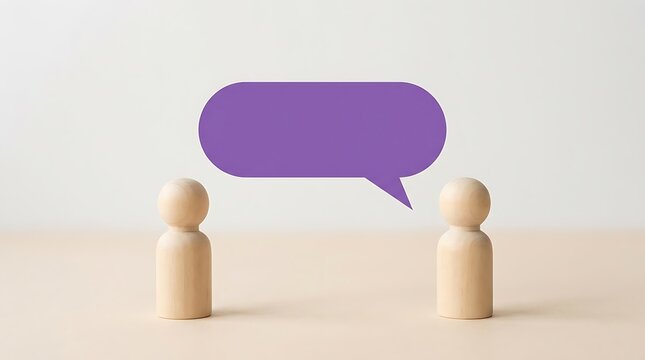 Two wooden peg dolls standing on a light beige surface facing each other with a large purple speech bubble floating between them for text space