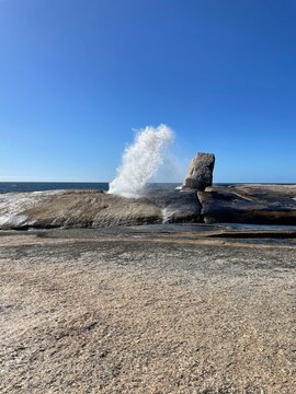 Dramatic sea spray burst at Bicheno Blowhole on a bright sunny day in Tasmania