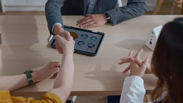 real estate agent and client shaking hands for a successful home insurance deal or property mortgage. Concept of house buying, financial agreement, and investment security at office