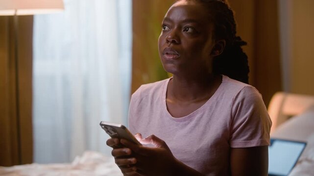 Angry African American business woman texting smartphone at home bedroom night annoyed female freelancer working late laptop nervous tired entrepreneur arguing mobile phone online SMS message stress