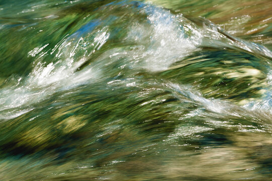 Flowing Water Surface with Green Reflections on a long exposure