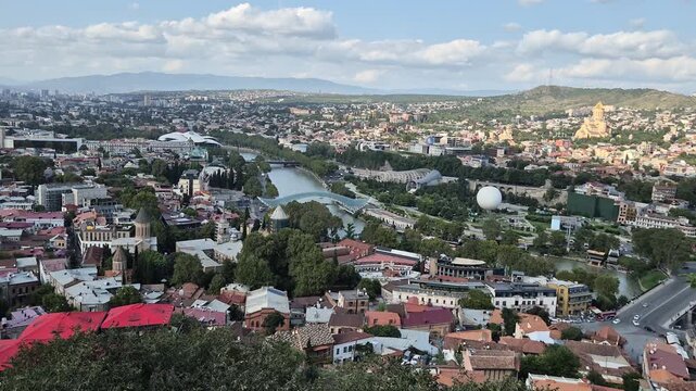 Footage of Panoramic Aerial View of Tbilisi Cityscape with Kura River and Peace Bridge