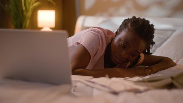 Tired African American woman sleeping closing laptop at home late night female student lying on bed finishing studying homework deadline fatigue insomnia resting bedtime computer digital education