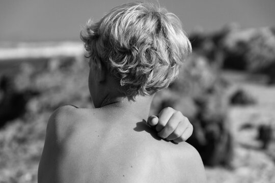 rear view of of young boys blond curly hair at the beach
