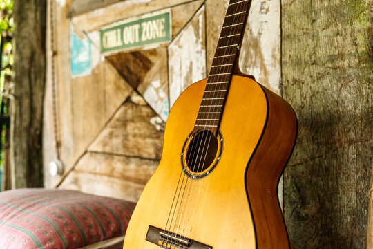 Cozy chill out zone with acoustic guitar, cushion, and rustic wooden wall