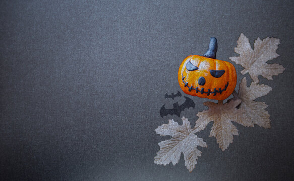Halloween card background idea, Halloween pumpkin with dry leaves on black background