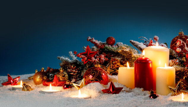 Christmas background with burning candles, ornaments and snow on blue