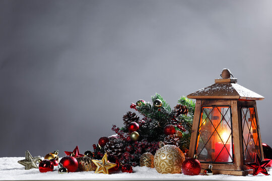 Christmas background with burning candles, ornaments and snow on blue
