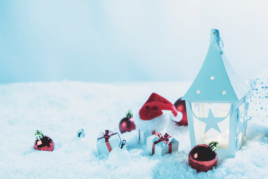 Christmas background with burning candles, ornaments and snow on blue