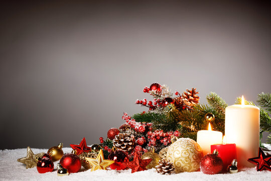 Christmas background with burning candles, ornaments and snow on blue