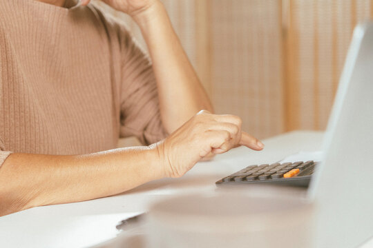 senior couple and documents with laptop for finance, budget planning or retirement annuity on sofa. Elderly man, woman or house with smile, computer or paperwork for pension fund or insurance