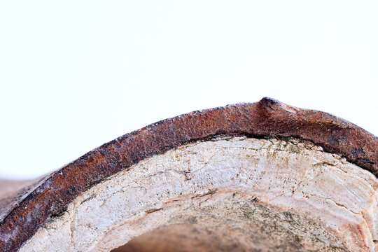 Section of industrial hot water boiler pipe with limescale deposits inside wall, reducing heat transfer efficiency, causing energy loss, corrosion, plumbing blockage, equipment failure