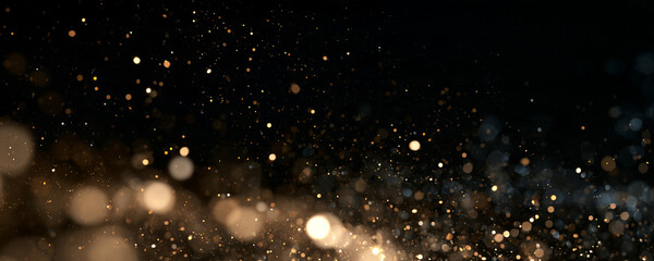 Gold dust particles scatter in a dark space. The tiny specks glow with soft warm light and varying intensity. This image captures a sparkling bokeh effect perfect for festive or background. © IvanLi