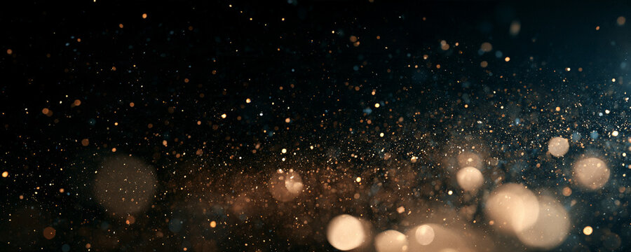 Floating particles create a mystical dust cloud effect under soft lighting. The dust is dispersed unevenly with varying glowing orange and blue hues. This image is ideal for backgrounds or.