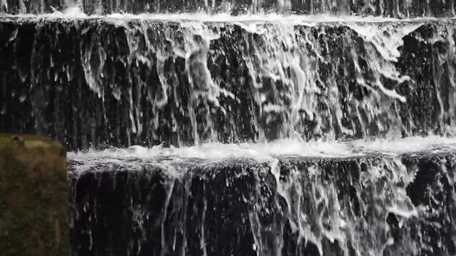 The water spray appears delicate against the serene backdrop, creating a cool and soothing natural atmosphere.