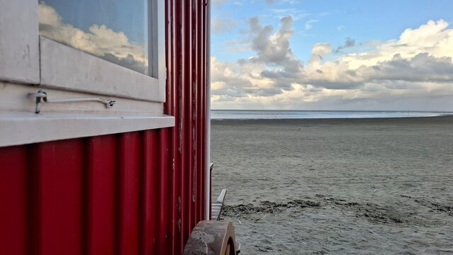Detail eines roten Badekarrens mit Strandblick