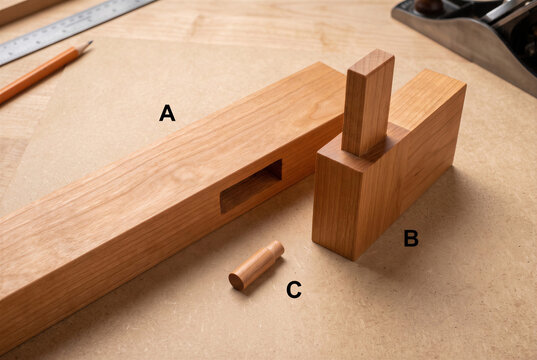 Handcrafted timber mortise and tenon joint with dowel peg for carpentry woodworking joinery.