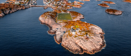 Aerial drone view of Henningsvaer football field and fishing village on rocky islands surrounded by ocean water in Lofoten Norway © Quality by Simon