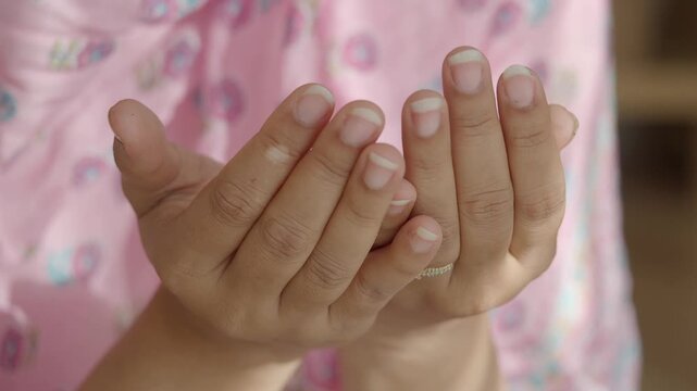 Close up of hands in prayer gesture receiving blessings during a religious ceremony