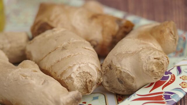 Fresh ginger root on a decorative tray, close-up with a slow pan showcasing its texture and natural form, ready for culinary use