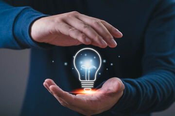 Innovation concept, a professional holding a glowing light bulb between hands, representing creativity, ideas, inspiration, problem solving, technology, business development, future opportunities. © Bordinthorn