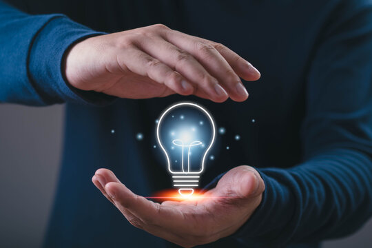 Innovation concept, a professional holding a glowing light bulb between hands, representing creativity, ideas, inspiration, problem solving, technology, business development, future opportunities.