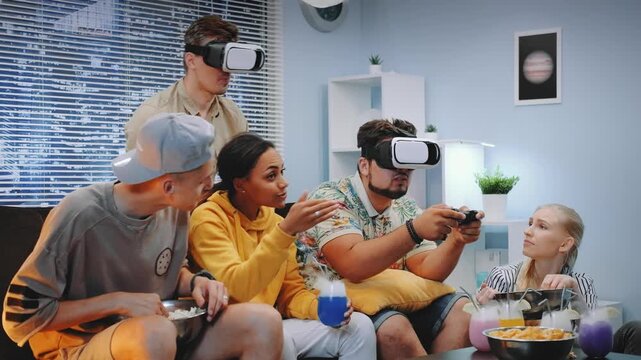 A group of seven young adults wearing virtual reality headsets play games and socialize in a modern indoor lounge with snacks and drinks during daytime.