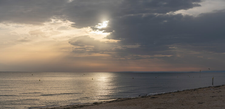 Langrune-Sur-Mer, France - 08 09 2026: Panoramic view of the sea, the beach and the sky with a ray of light reflecting on the water in the morning